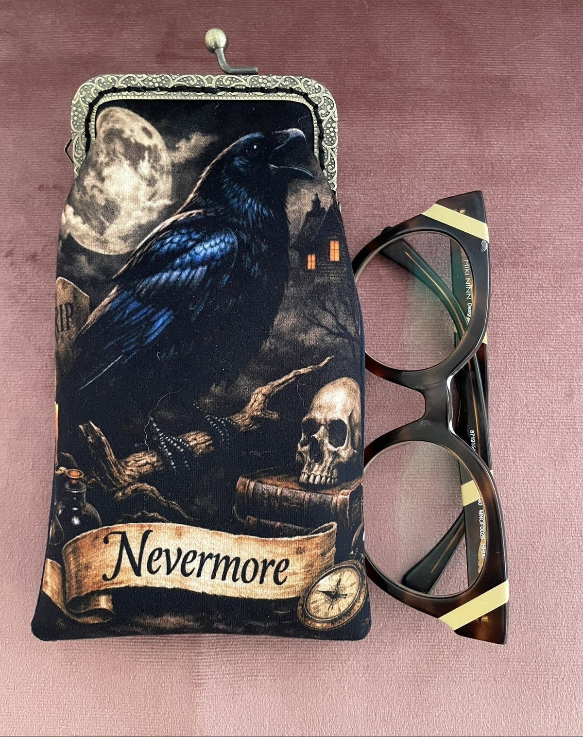 Vue rapprochée de l'illustration corbeau Nevermore et du fermoir couleur bronze étui lunettes Le Comptoir de Suzanne