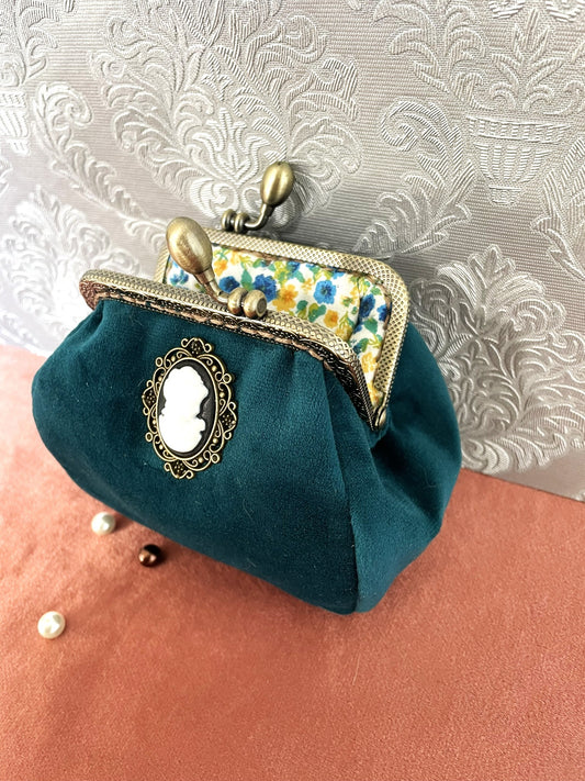 Porte-monnaie artisanal en velours bleu canard avec un camée central vintage et fermoir bronze ciselé.