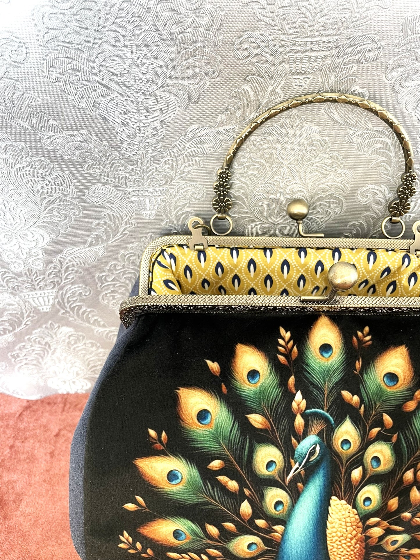Intérieur du sac ouvert montrant la doublure jaune à motifs graphiques et le fermoir rétro.