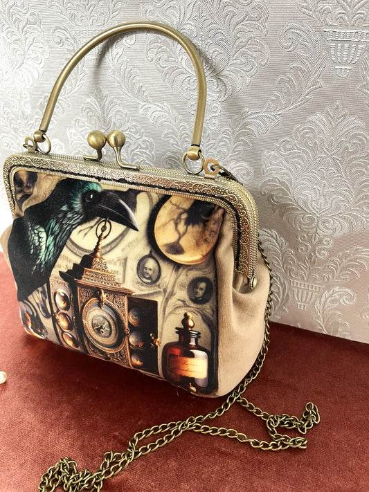 Sac vintage à fermoir bronze avec illustration de corbeau et objets anciens.