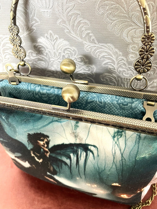 Sac vintage avec illustration de silhouette ailée et lueurs magiques.