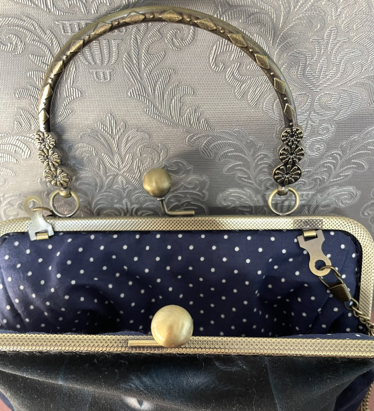 Vue ouverte de la pochette rétro en velours bleu nuit et doublure à pois blancs Le Comptoir de Suzanne