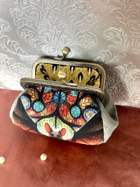 Vue intérieure du porte-monnaie chauve-souris avec doublure graphique jaune moutarde et bleu, fermoir effet bronze