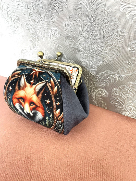 Soufflet en velours doux gris bleu et fermeture clic-clac rétro en bronze sur un porte-monnaie renard de créateur.