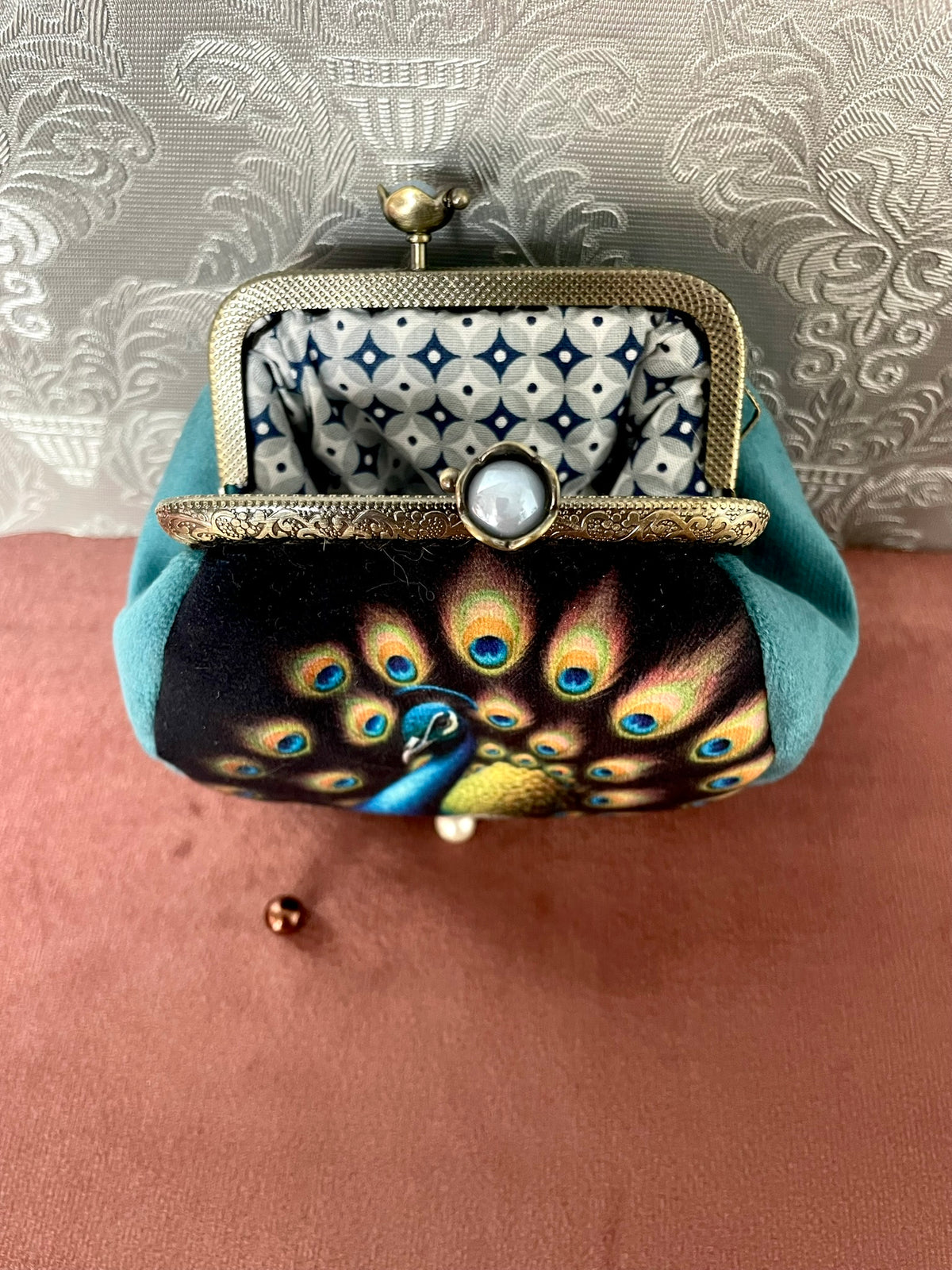 Vue du fermoir ouvert couleur bronze à boules nacrées et doublure géométrique porte-monnaie paon Le Comptoir de Suzanne