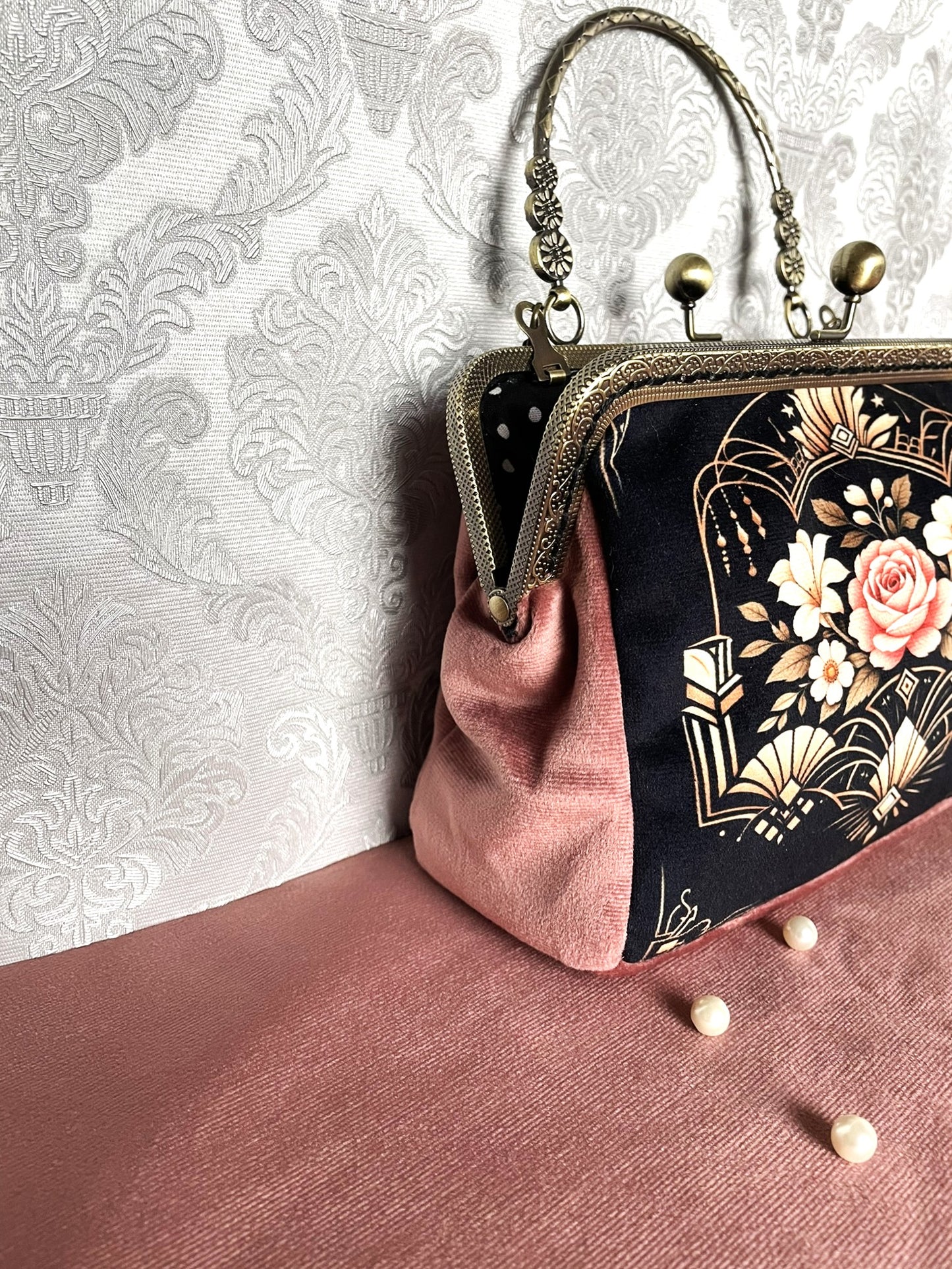 Vue de face du sac bandoulière de style Art Déco avec motif de rose ancienne, anse rigide travaillée et chaîne dorée amovible.
