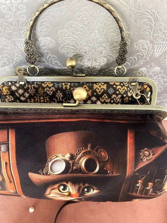 Intérieur ouvert du sac "L'Alchimiste" montrant une doublure en coton aux motifs graphiques ocres et noirs.