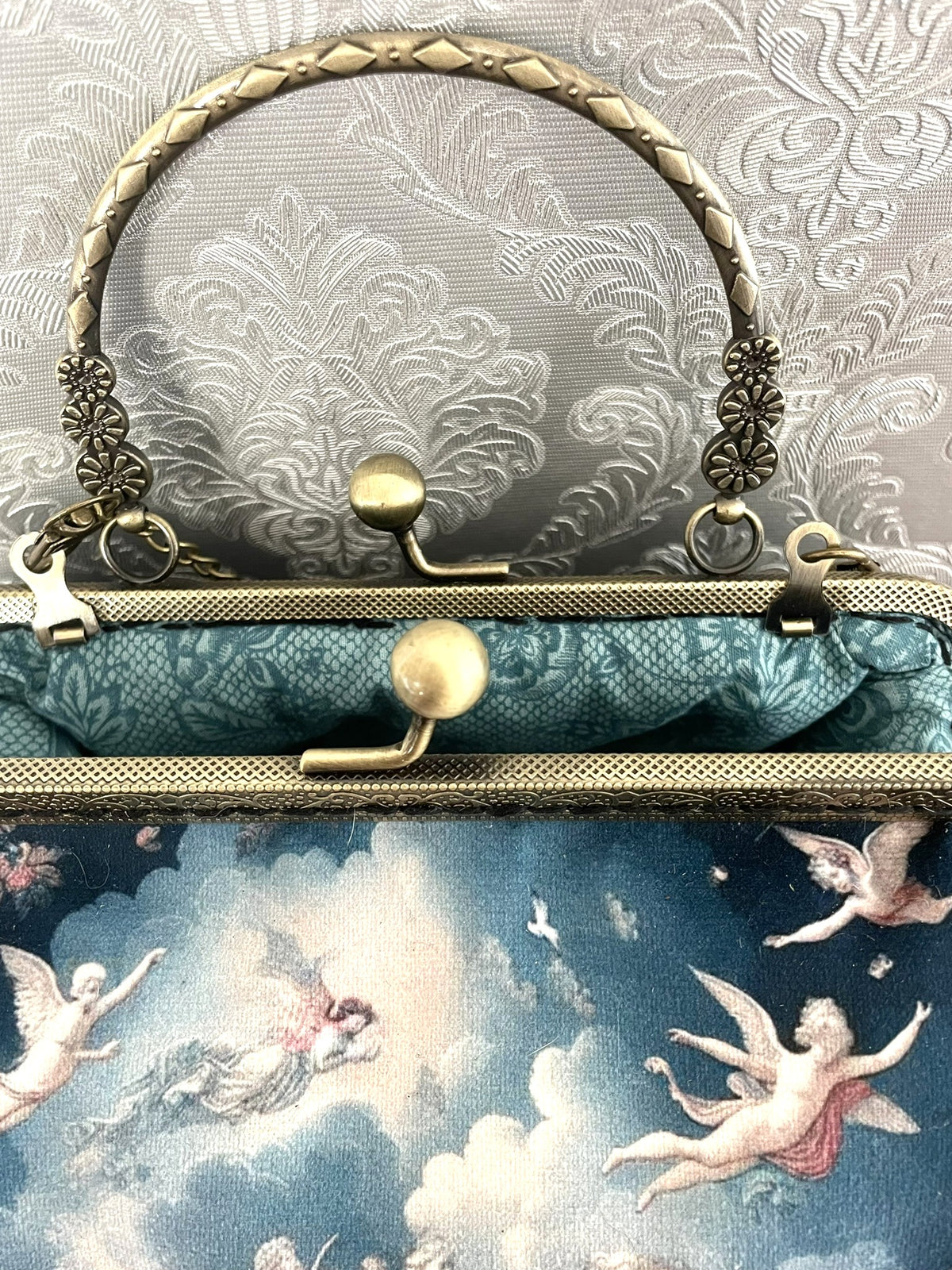 Vue interieur doublure turquoise motif dentelle et fermoir bronze d'un sac retro anges