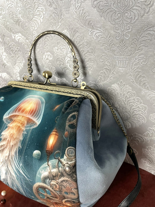 Vue de trois-quarts sac retro velours bleu motif meduse lumineuse steampunk et engrenages avec fermoir