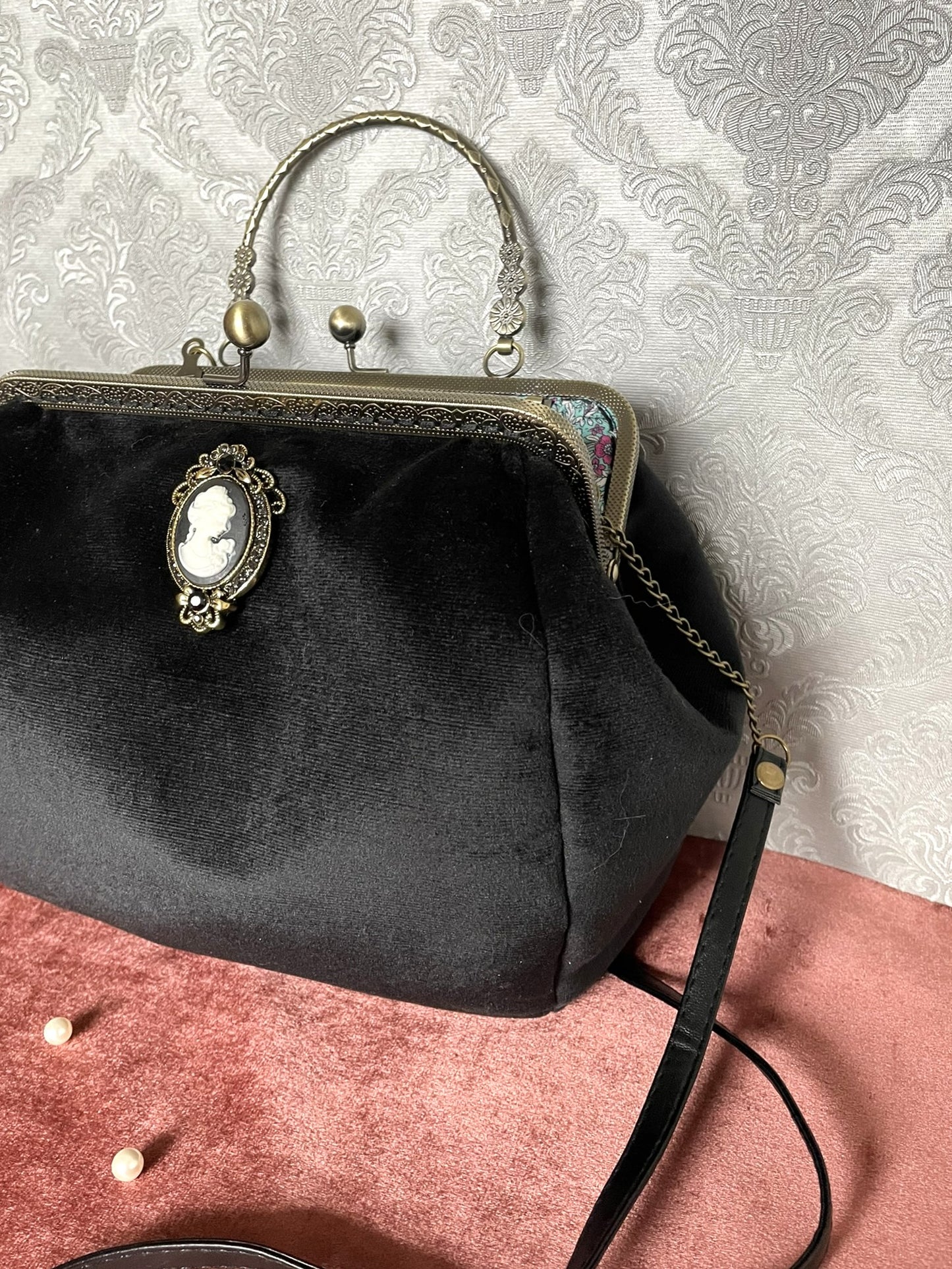 Gros plan sur le fermoir baiser travaillé en bronze antique et l'attache bandoulière du sac artisanal.