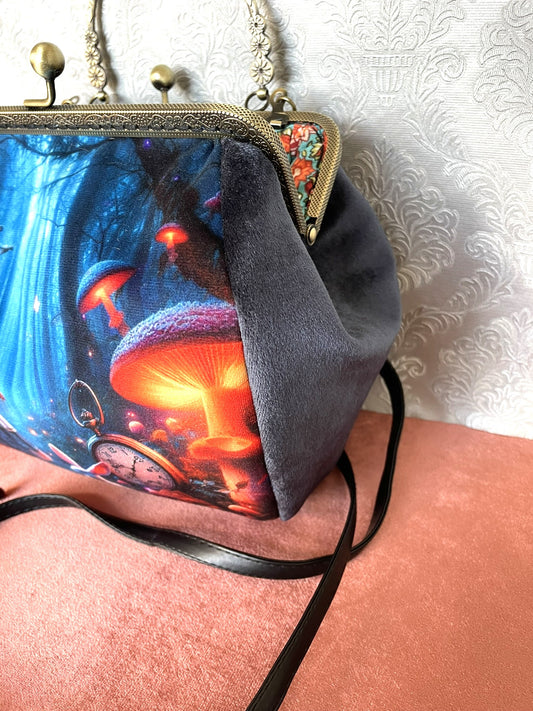 Vue latérale du sac montrant le soufflet en velours bleu profond et la bandoulière noire.