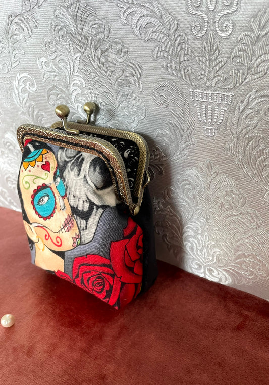 Détail du velours noir au dos et de la finition bronze du porte-monnaie "L'Éternelle Élégance".