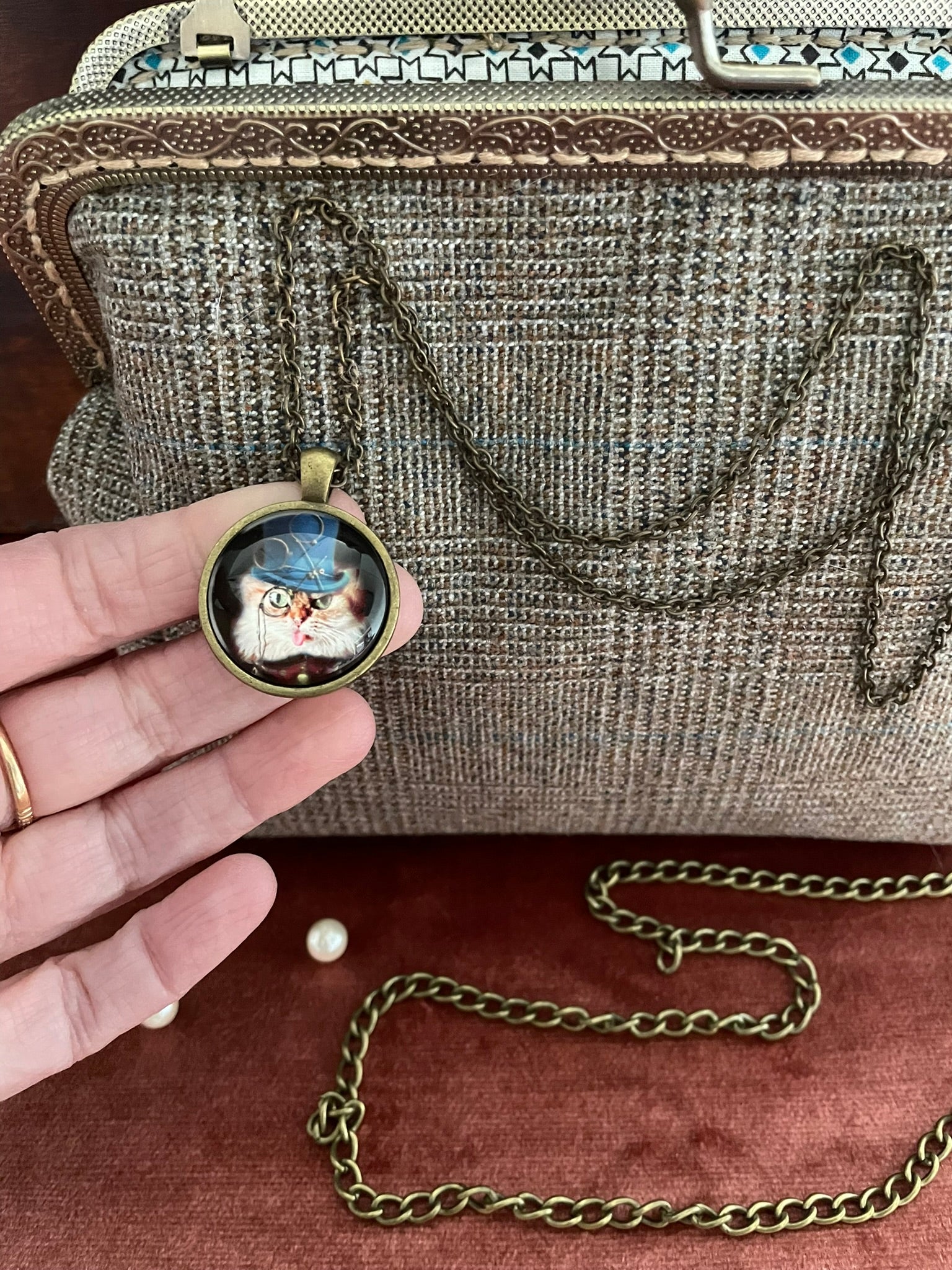 Détail du bijou de sac chaîne et médaillon chat aristocrate style steampunk.
