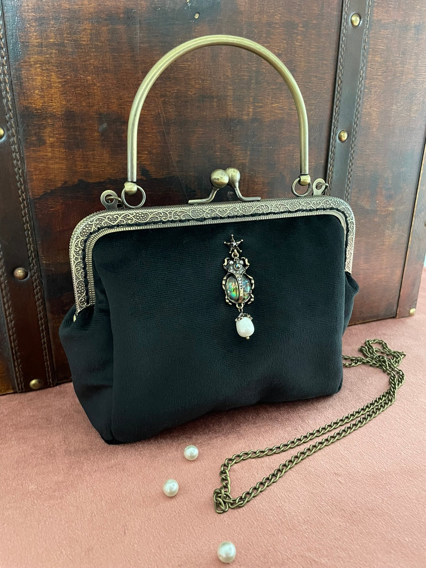 Détail de l'anse rigide en métal bronze ciselé et du fermoir rétro.