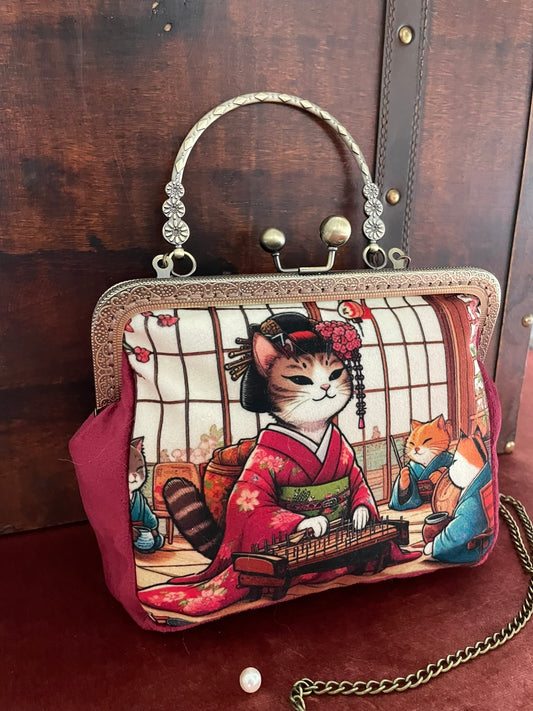 Gros plan sur la poignée métallique ciselée et le fermoir rétro du sac geisha.