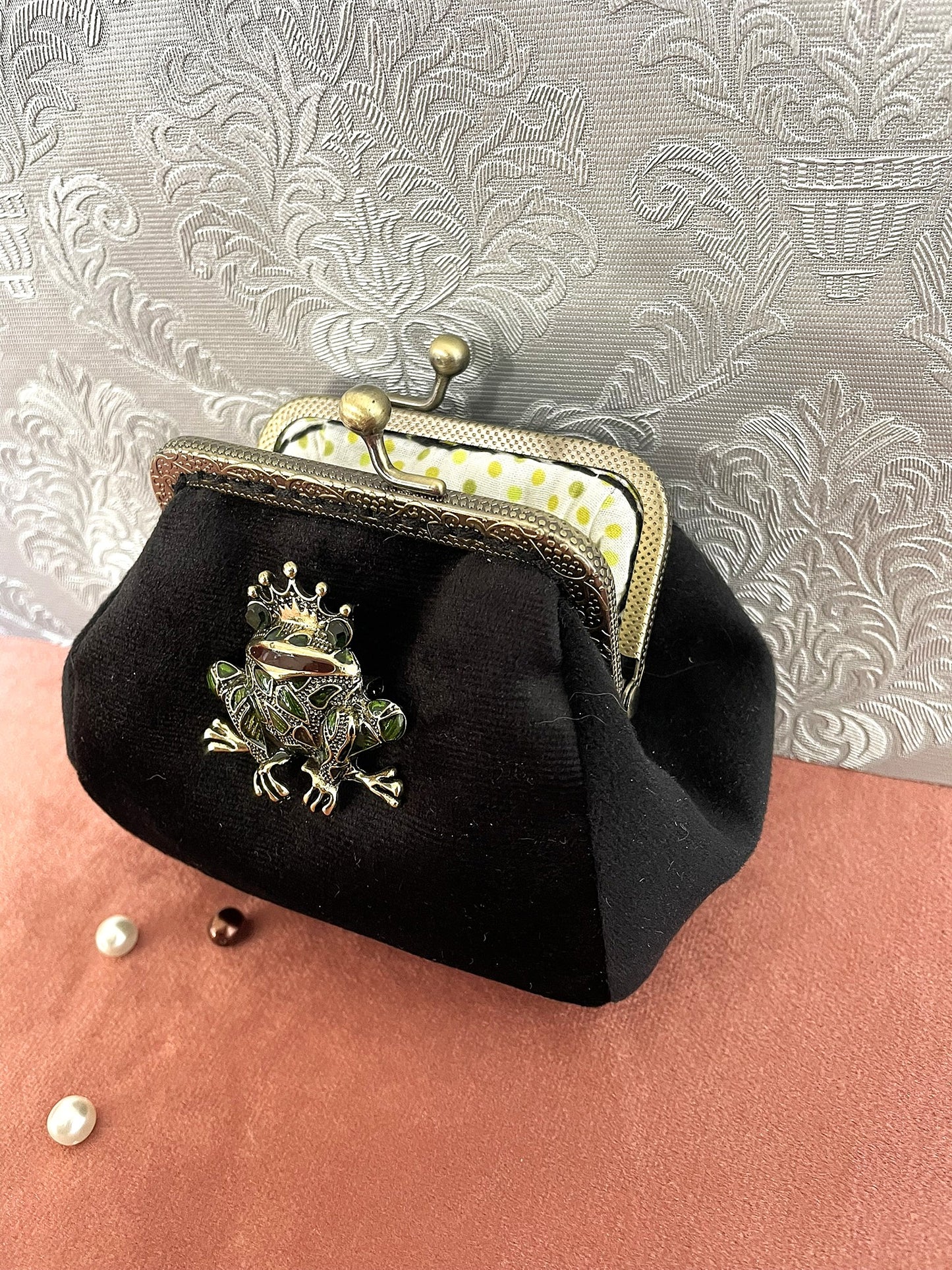 Détail de la grenouille à couronne dorée et de la texture douce du velours noir dequalité.