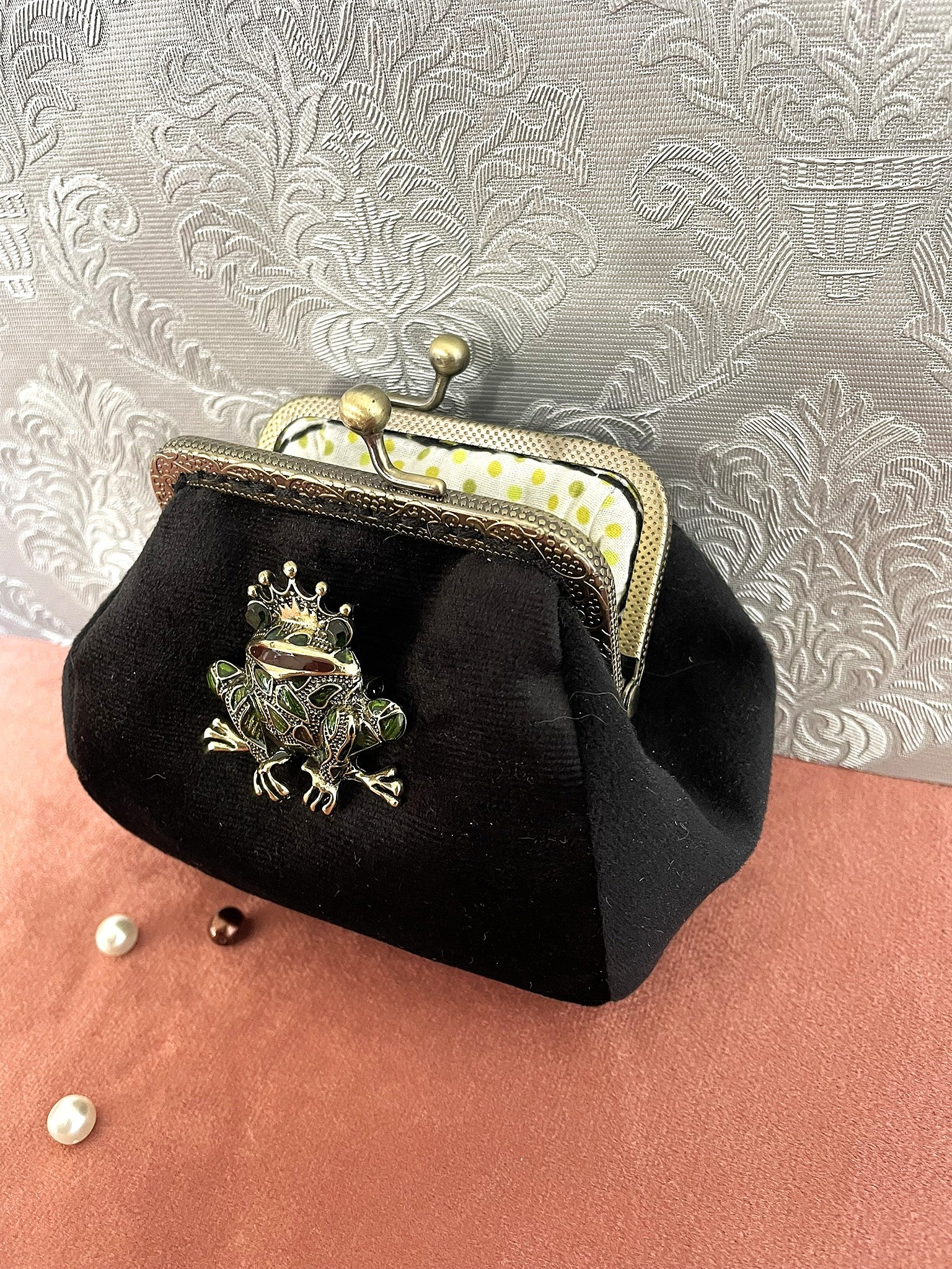 Détail de la grenouille à couronne dorée et de la texture douce du velours noir dequalité.
