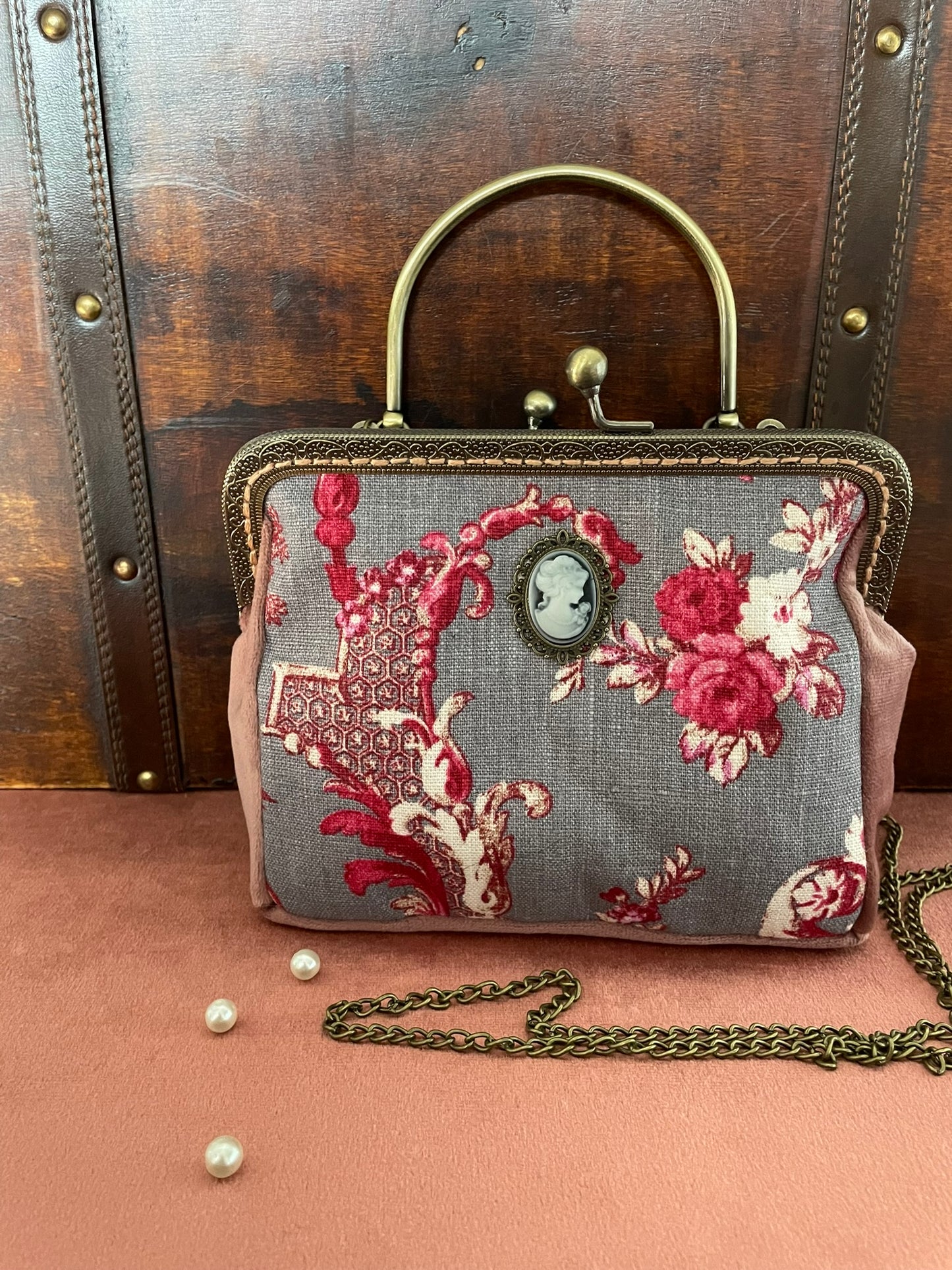 Détail du fermoir rétro à boules et de l'anse rigide ciselée en métal effet bronze vieilli.