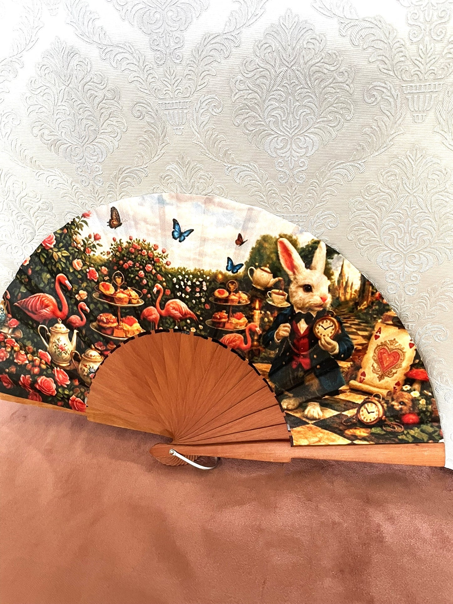 Détail de l'illustration féerique du Lapin Blanc avec sa montre à gousset dans un jardin de roses sur l'éventail en bois de fruitier.