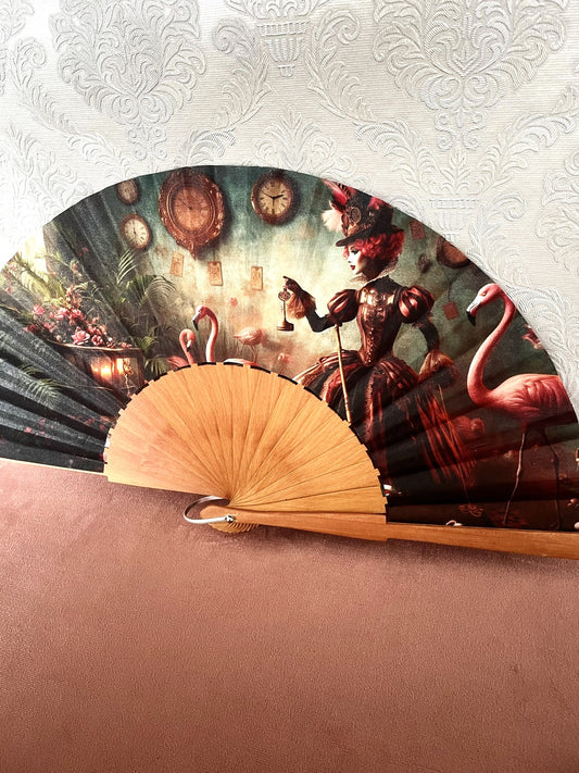 Détail du tissu exclusif d'un éventail en bois montrant une femme élégante en tenue baroque steampunk avec une clé, des horloges anciennes et des flamants roses.