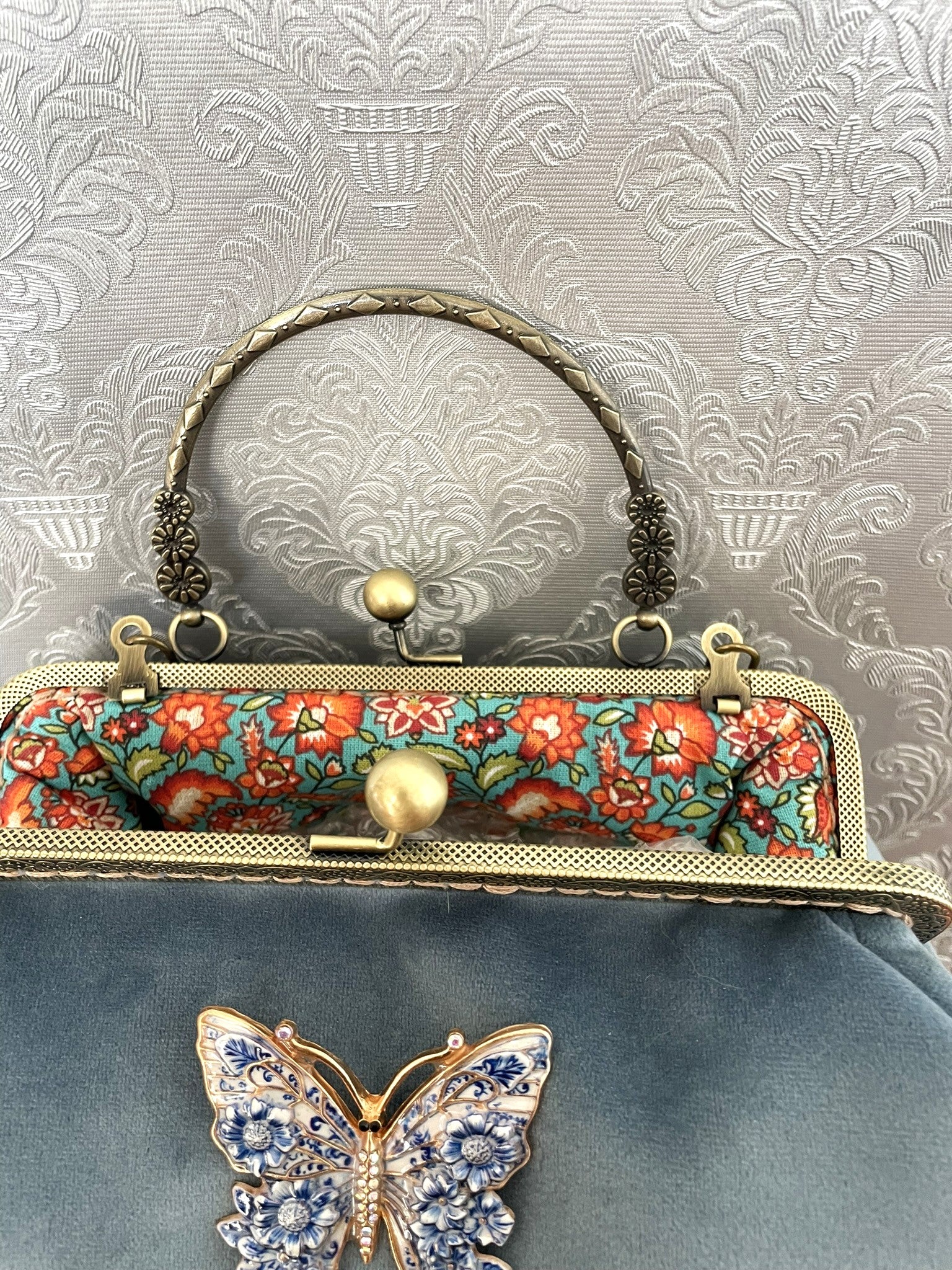 Intérieur ouvert du sac bleu montrant la doublure en coton aux fleurs oranges.