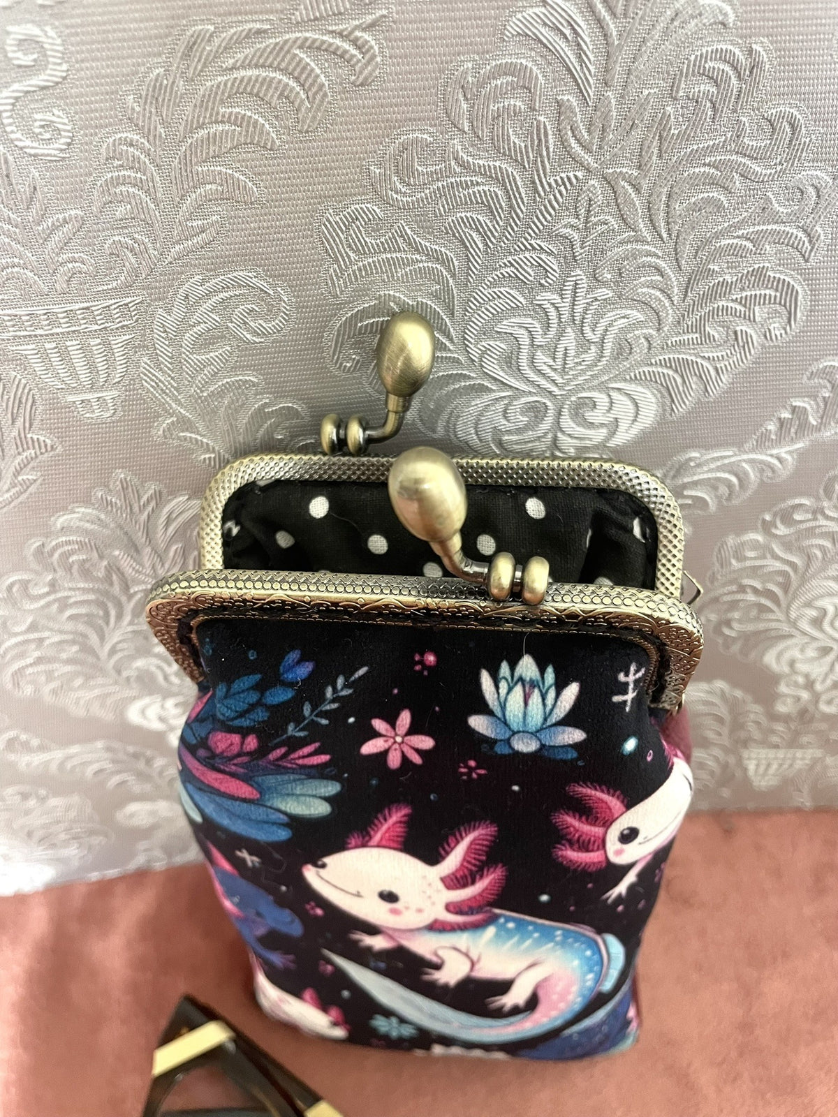 Gros plan fermoir bronze et doublure a pois noirs d'un etui a lunettes axolotls