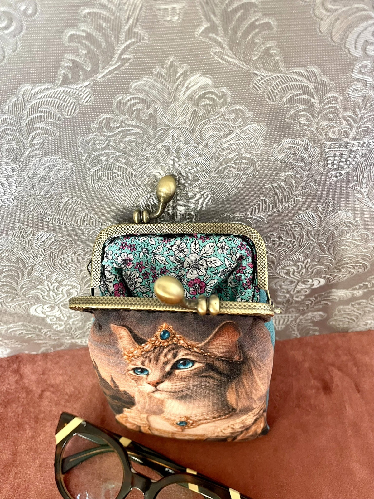 Gros plan fermoir effet bronze et doublure coton fleurie turquoise d'un etui a lunettes retro
