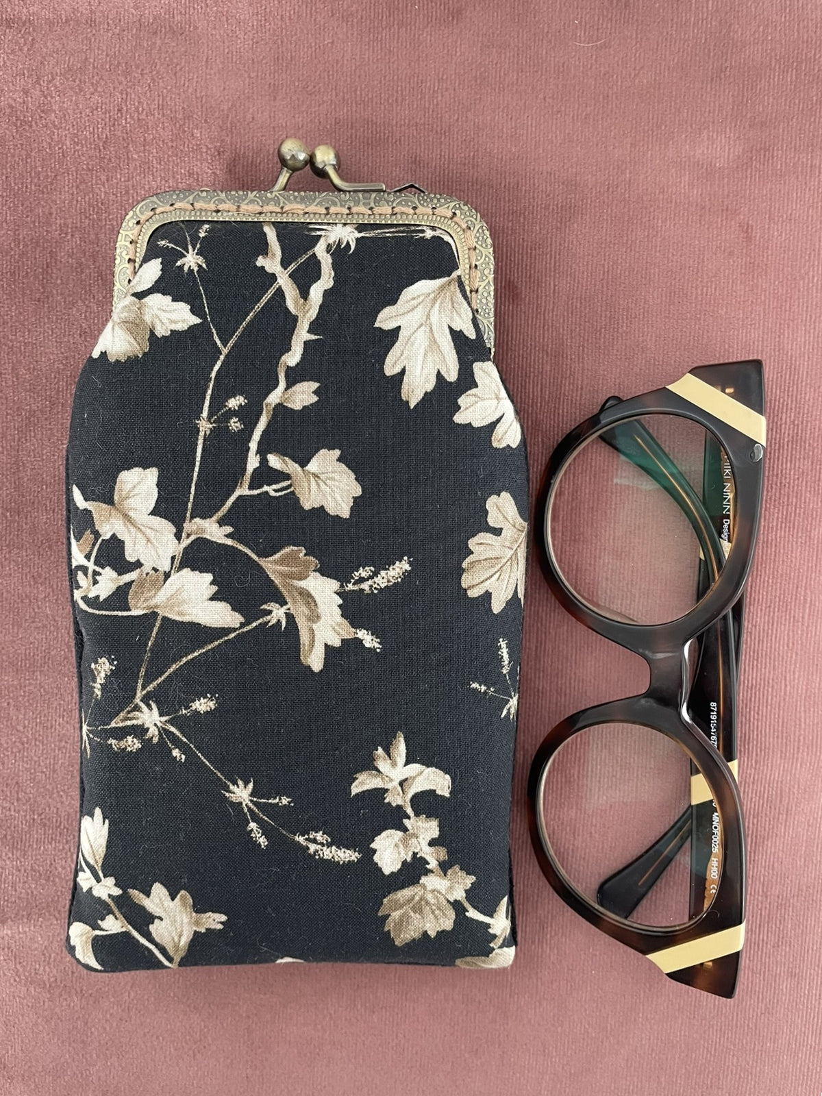 Vue à plat du motif botanique feuillages beige et noir étui à lunettes avec lunettes Le Comptoir de Suzanne