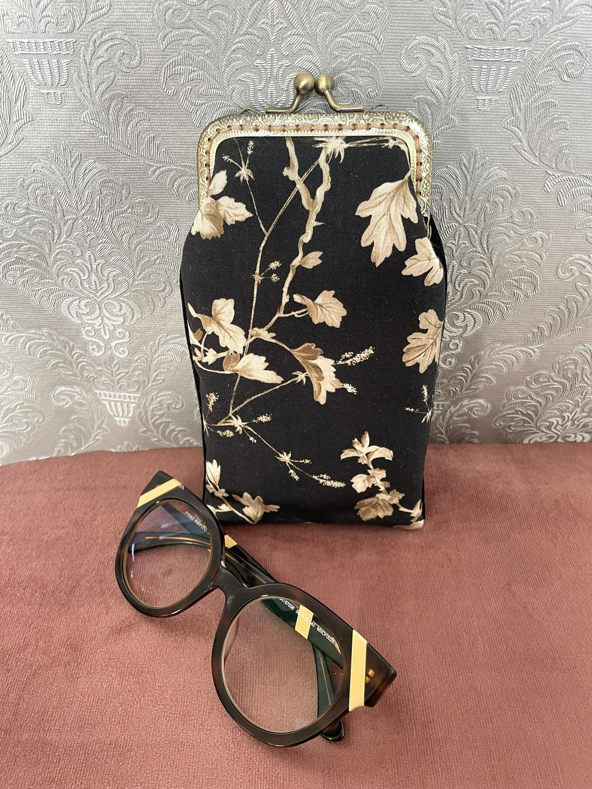Vue de face étui à lunettes rétro en coton floral noir et beige avec lunettes Le Comptoir de Suzanne