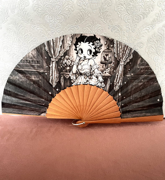Éventail artisanal ouvert Le Comptoir de Suzanne en bois avec tissu exclusif représentant Betty Boop en robe dentelle dans un boudoir rétro noir et blanc.