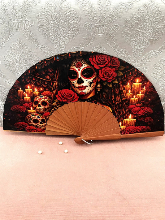 Éventail artisanal ouvert Le Comptoir de Suzanne en bois de fruitier avec tissu exclusif représentant une Catrina entourée de bougies allumées et de calaveras.