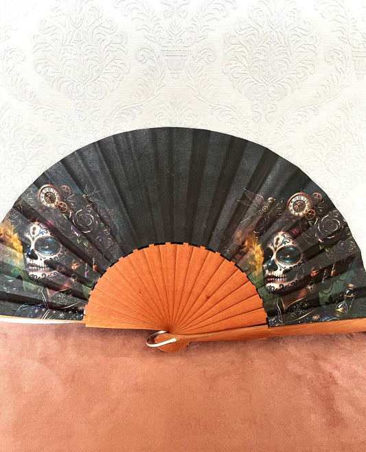Éventail artisanal ouvert Le Comptoir de Suzanne en bois de fruitier avec tissu exclusif représentant deux portraits de Catrina dans un style steampunk gothique.