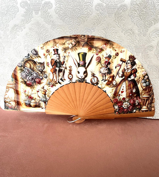 Éventail artisanal ouvert Le Comptoir de Suzanne en bois avec tissu exclusif représentant une scène vintage réunissant les personnages d'Alice au Pays des Merveilles.