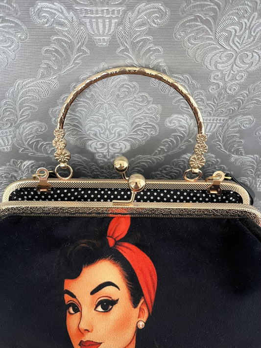 Zoom sur le fermoir cliquet en bronze doré ciselé et la doublure intérieure à pois noirs et blancs de style rétro pin-up.