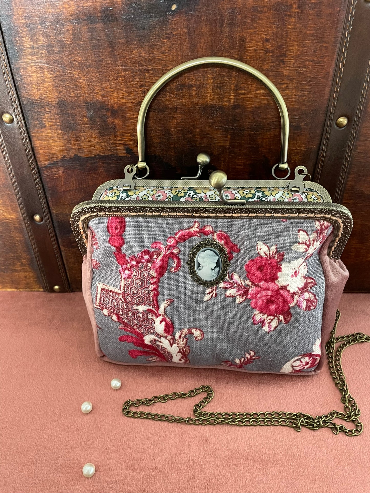 Détail du fermoir rétro à boules et de l'anse rigide ciselée en métal bronze vieilli.