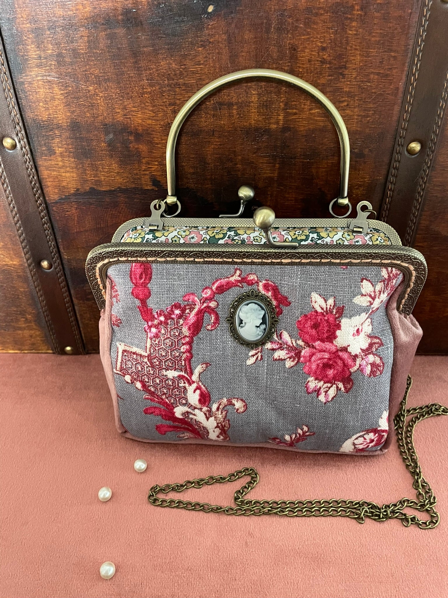 Détail du fermoir rétro à boules et de l'anse rigide ciselée en métal bronze vieilli.