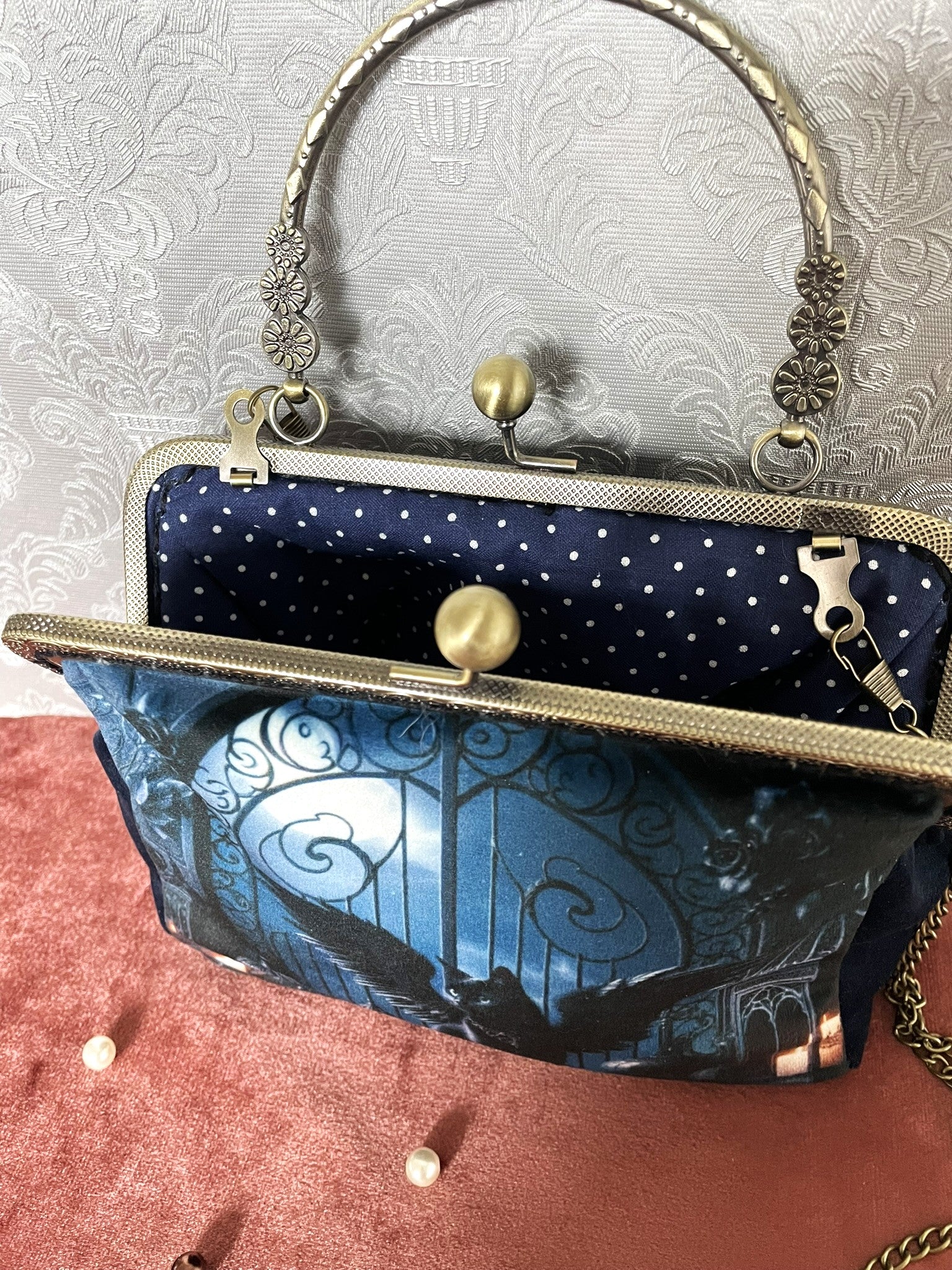 Vue intérieure du sac "Le Gardien Sombre" révélant sa doublure bleu à pois blancs et son grand compartiment.