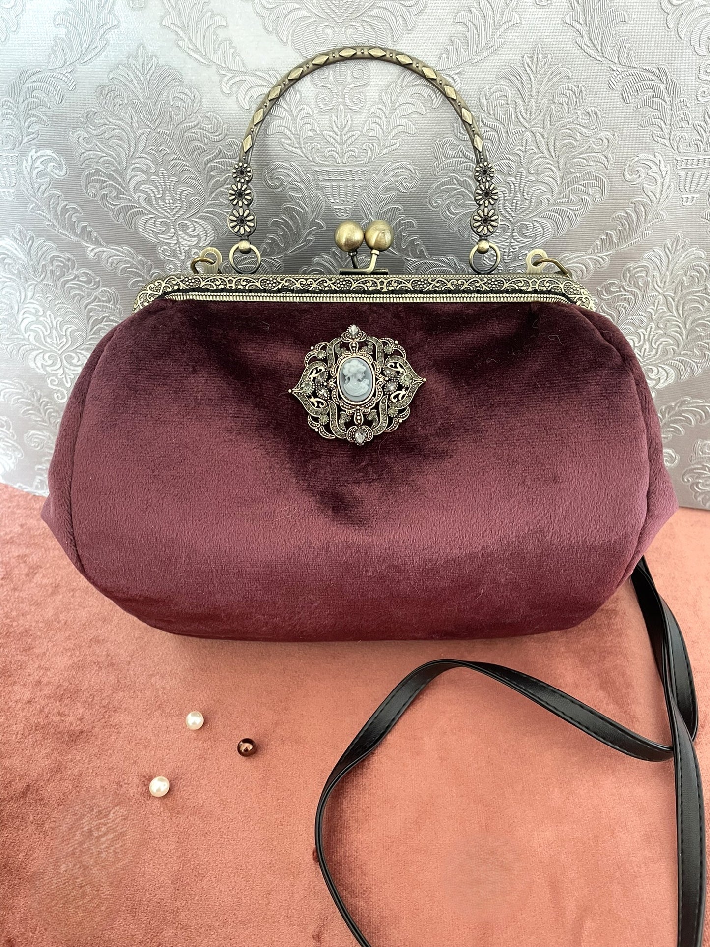 Fermoir métallique rétro type kiss-lock avec motifs floraux ciselés.