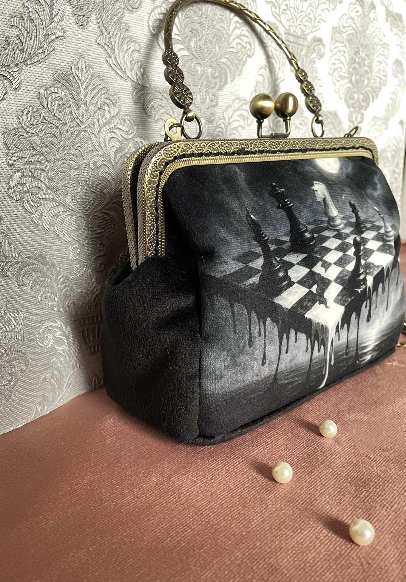 Détail du soufflet latéral en velours noir  et de la monture rétro métallique travaillée sur la pochette clutch artisanale Le Comptoir de Suzanne.