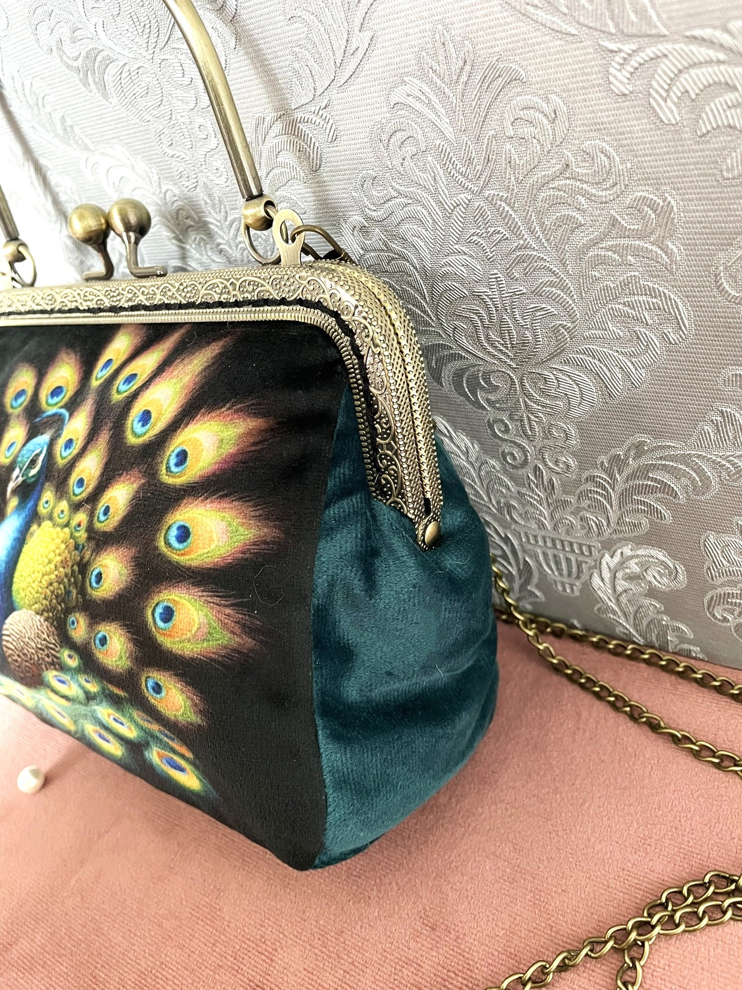 Zoom de profil sur le soufflet en velours bleu canard et la monture rétro métallique bronze gravée de la pochette Le Comptoir de Suzanne.