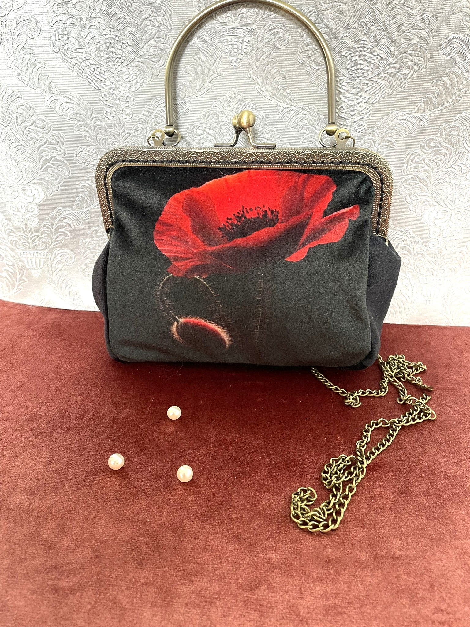 Pochette vintage noire avec coquelicot rouge et armature bronze.