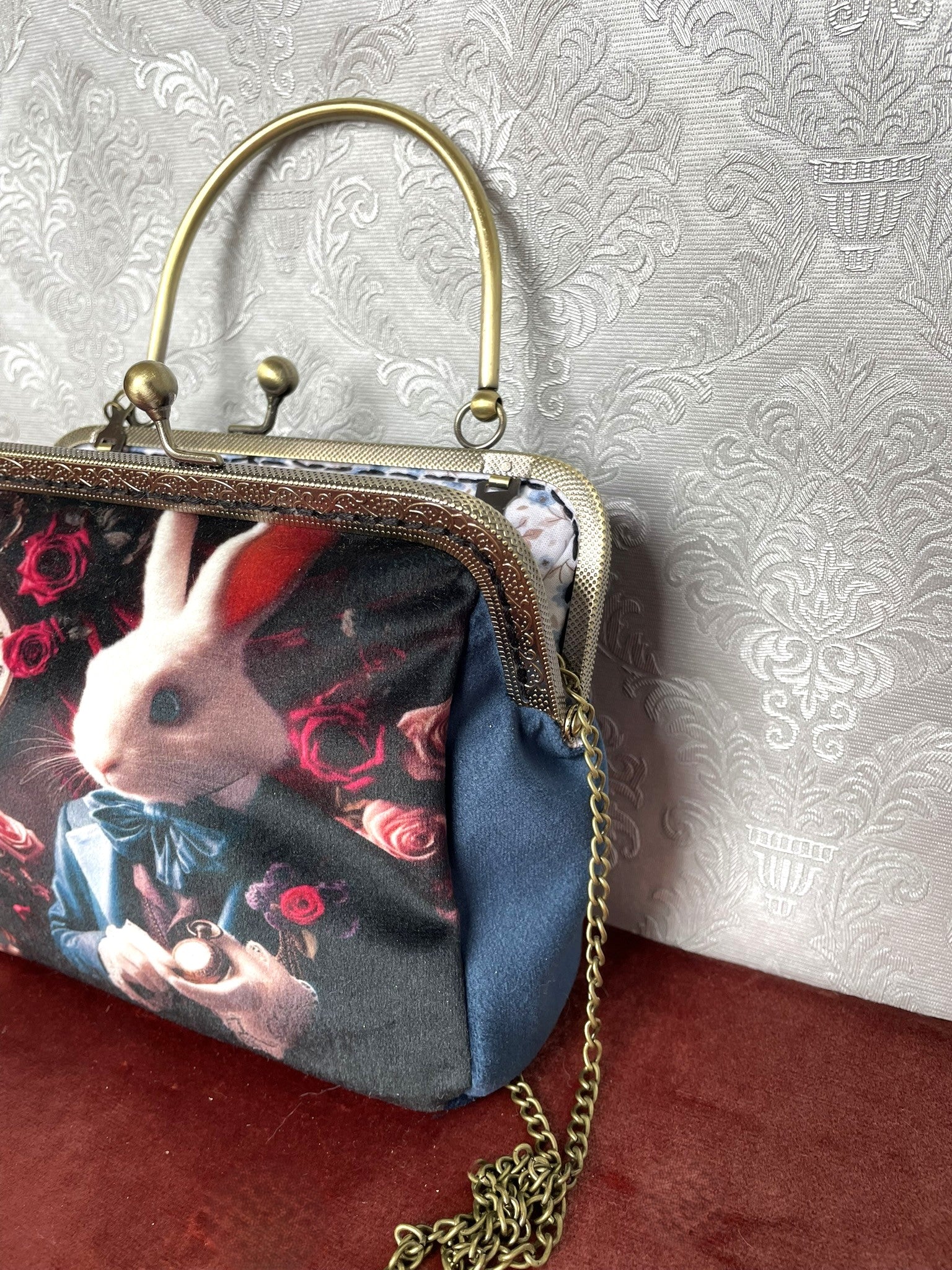 Sac rétro avec lapin élégant en habit bleu, décor floral et horloge.