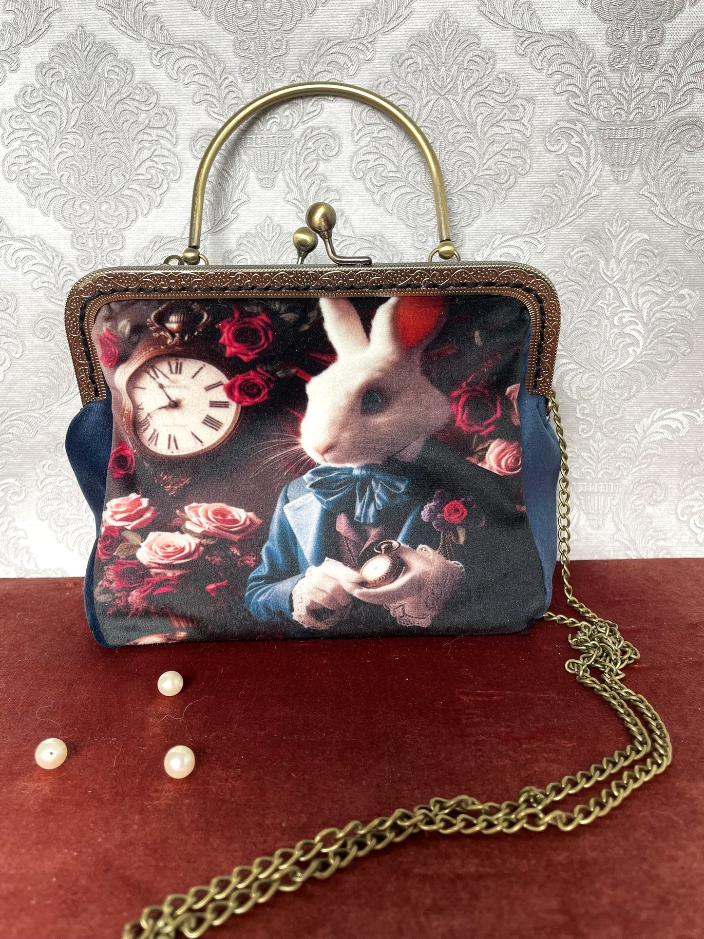 Pochette vintage avec lapin inspiré d’Alice, roses rouges et horloge ancienne.