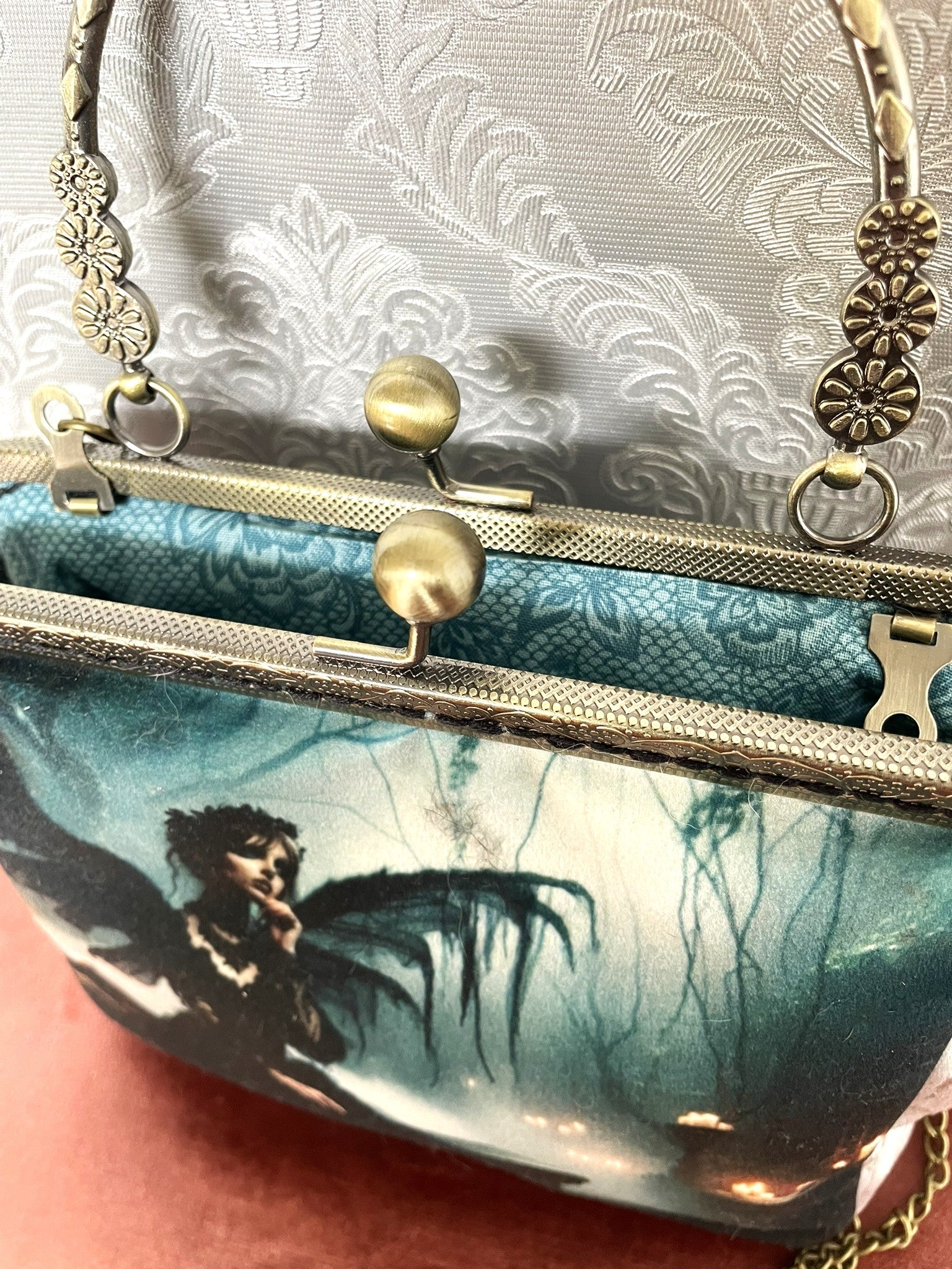 Sac vintage avec illustration de silhouette ailée et lueurs magiques.