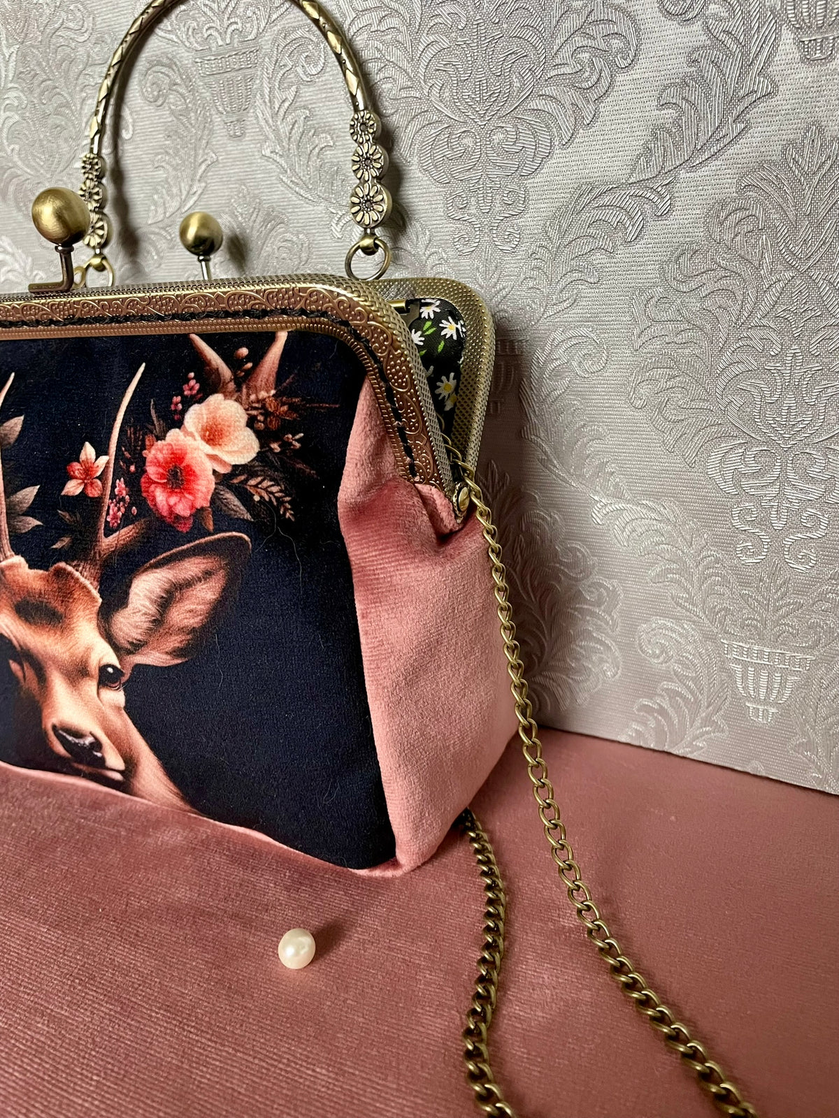 Vue de trois-quarts de la pochette rétro en velours rose poudré motif cerf couronné de fleurs Le Comptoir de Suzanne