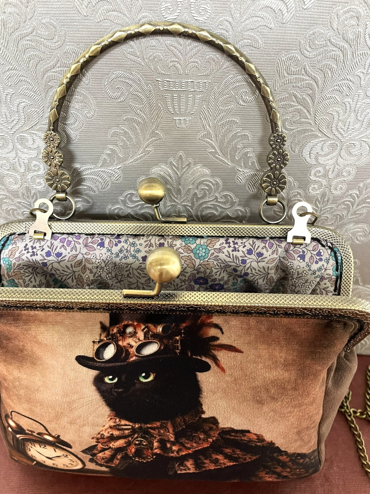 Vue du fermoir ouvert couleur bronze et de la doublure coton fleurie liberty de la pochette chat steampunk Le Comptoir de Suzanne