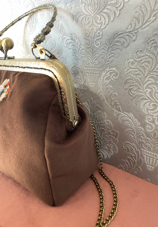 Vue de profil de la pochette rétro en velours marron chocolat et poignée couleur bronze Le Comptoir de Suzanne