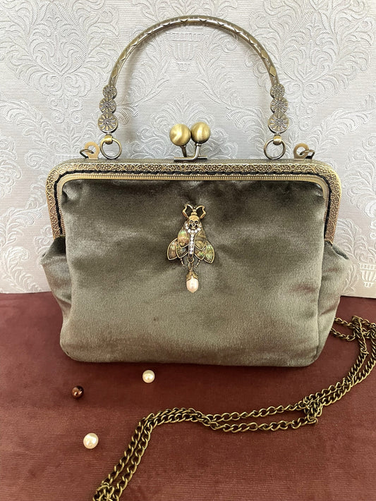 Pochette rétro velours vert sauge ornée d'un bijou phalène papillon de nuit avec poignée et chaînette couleur bronze Le Comptoir de Suzanne