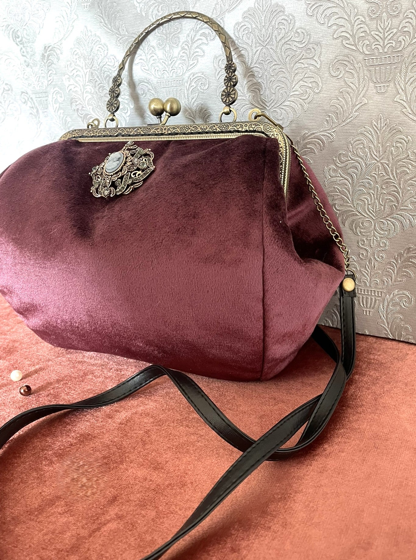 Sac de soirée en velours haut de gamme avec ornements métalliques vieillis.