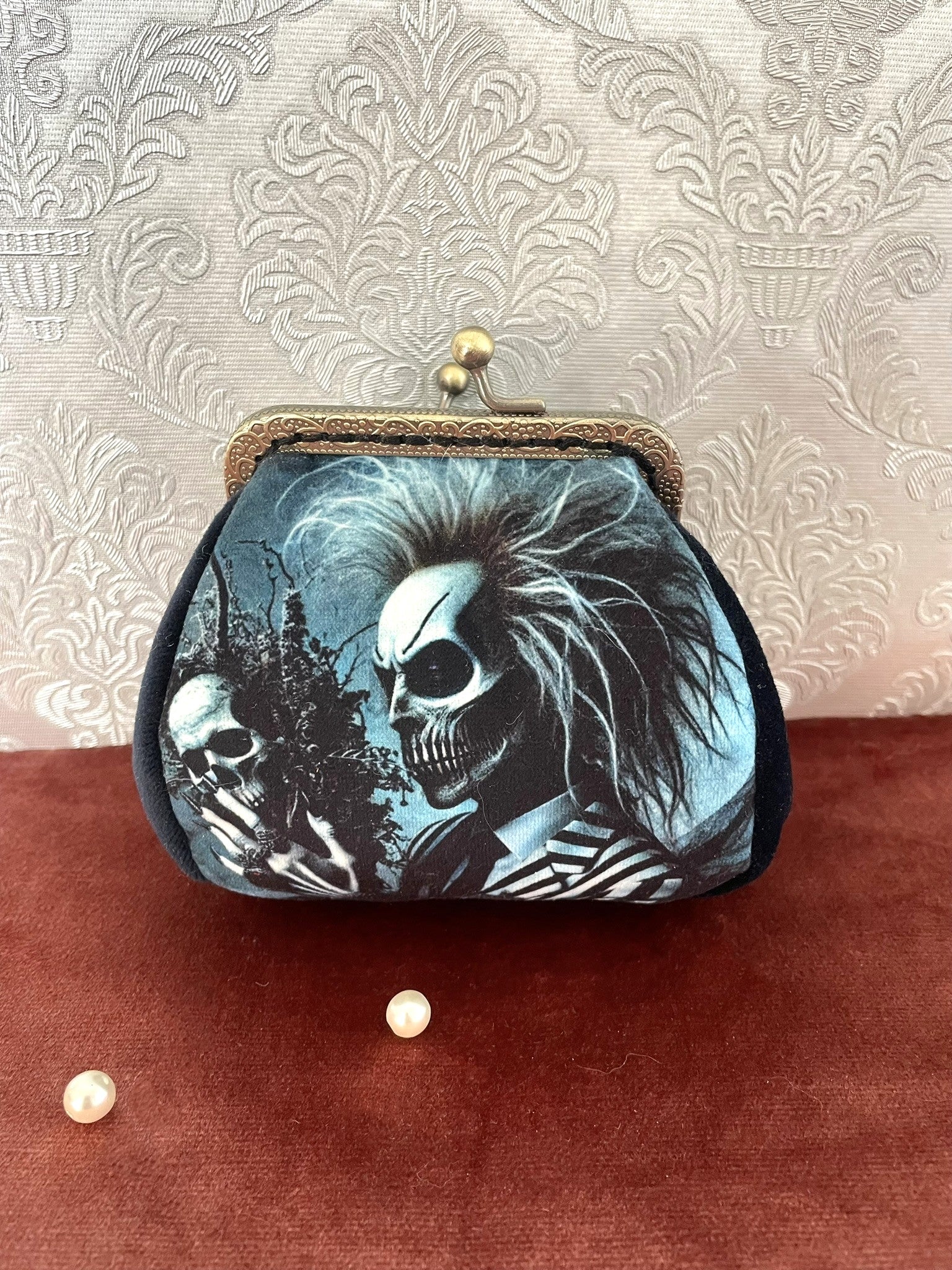 Porte-monnaie rétro avec illustration de squelette punk style Beetlejuice et côtés en velours.